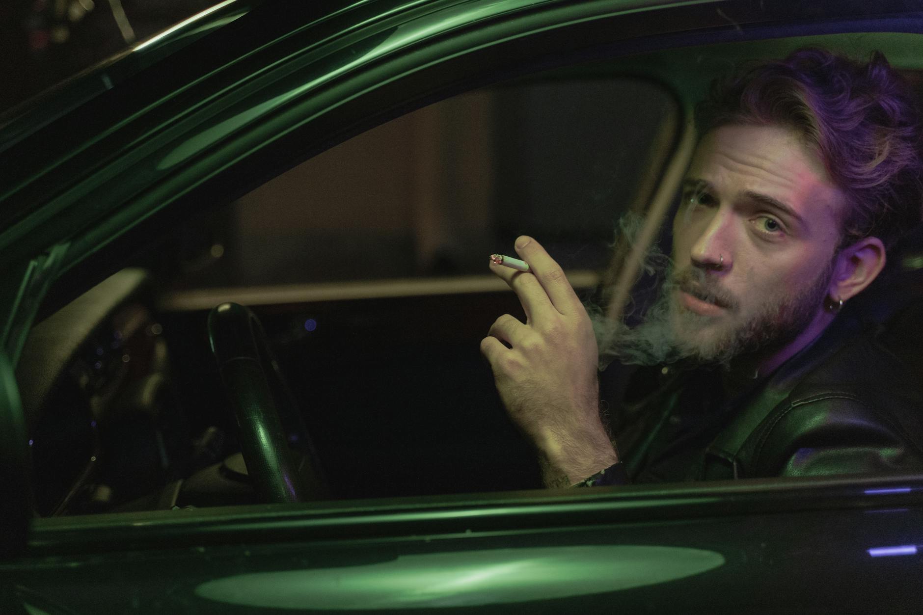 a man smoking cigarette inside the car